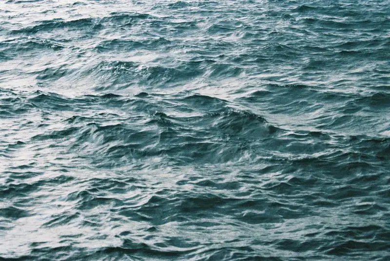 Close ripples and peaks in deep blue-green water.